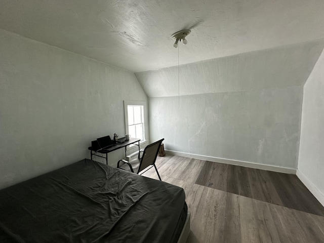 bedroom with hardwood / wood-style flooring and lofted ceiling