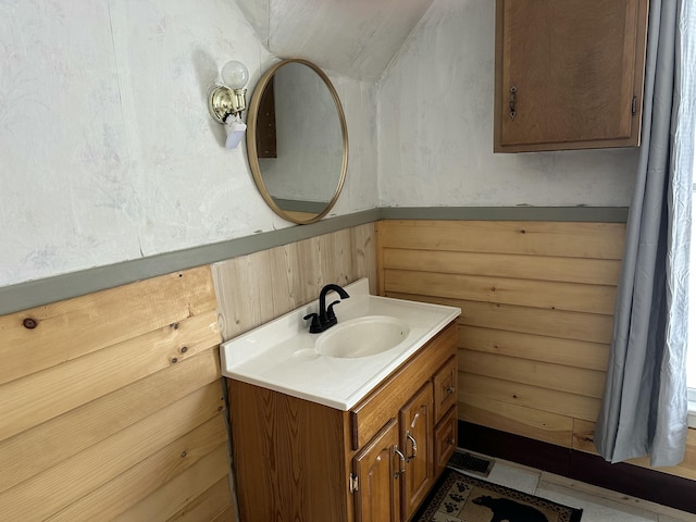 bathroom with vanity and wood walls