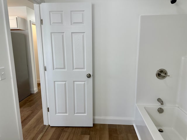 bathroom featuring washtub / shower combination and wood-type flooring