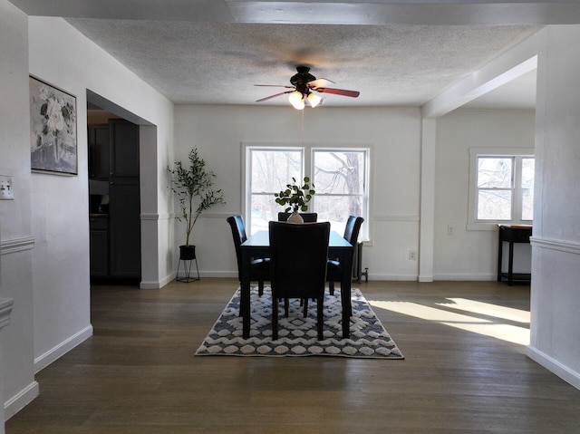 dining room with a textured ceiling, dark hardwood / wood-style floors, and ceiling fan