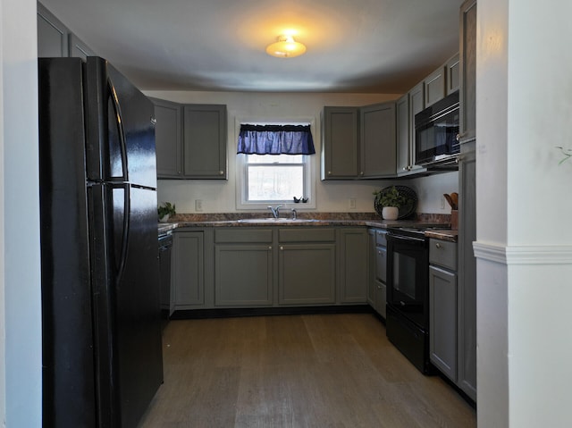 kitchen featuring black appliances, gray cabinetry, sink, and dark wood-type flooring