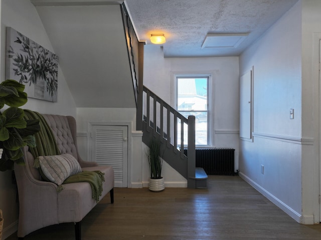 interior space featuring hardwood / wood-style flooring, radiator heating unit, and a textured ceiling