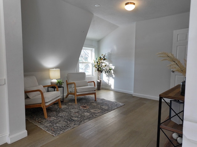 sitting room with wood-type flooring and lofted ceiling