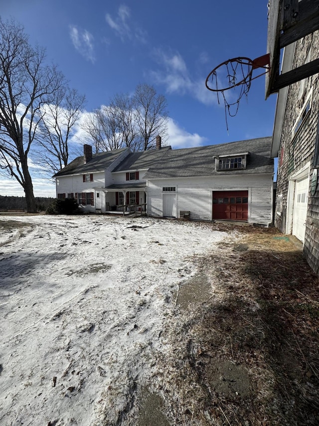 view of snow covered back of property