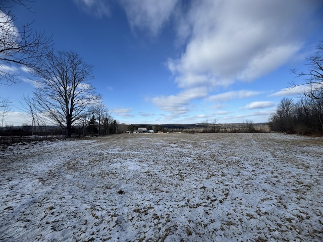 snowy yard featuring a rural view