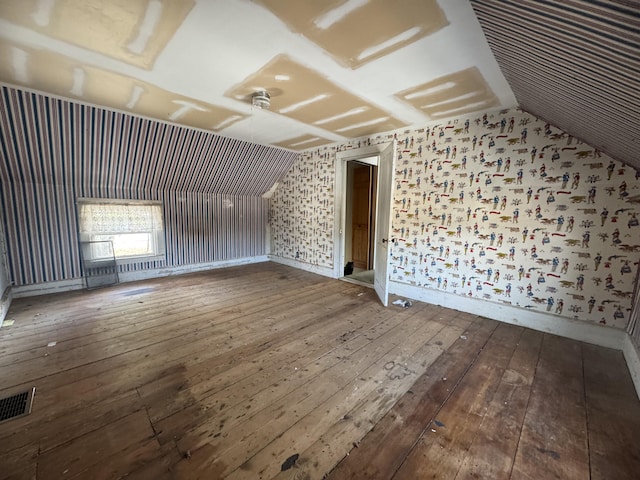 interior space with hardwood / wood-style floors and vaulted ceiling