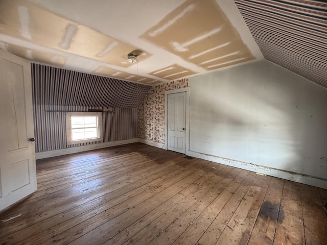 bonus room with lofted ceiling and wood-type flooring