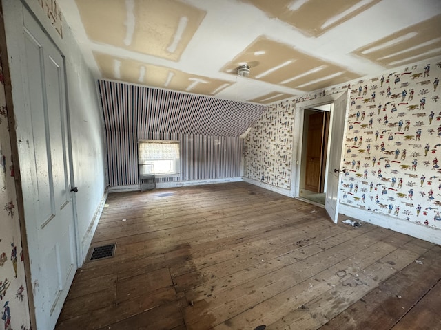 spare room featuring dark hardwood / wood-style flooring and lofted ceiling