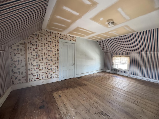 bonus room with hardwood / wood-style floors and vaulted ceiling