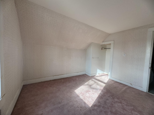 additional living space featuring carpet flooring and lofted ceiling