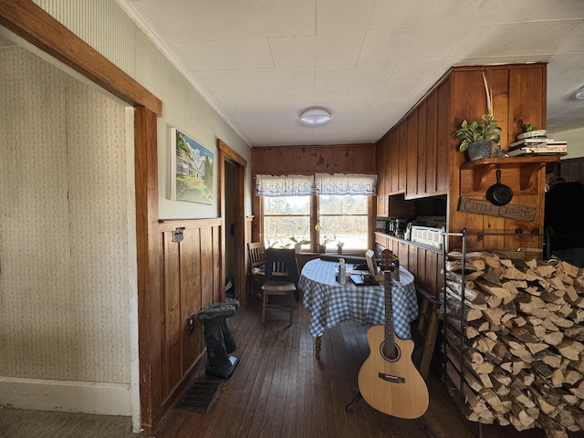 bedroom featuring wood walls, wood-type flooring, and ornamental molding