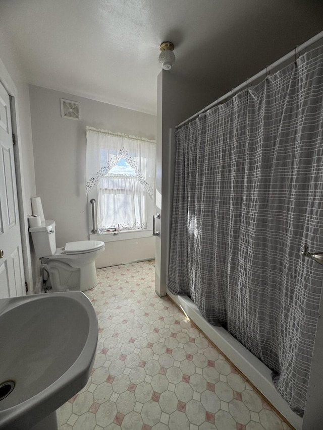 bathroom with a shower with curtain and toilet