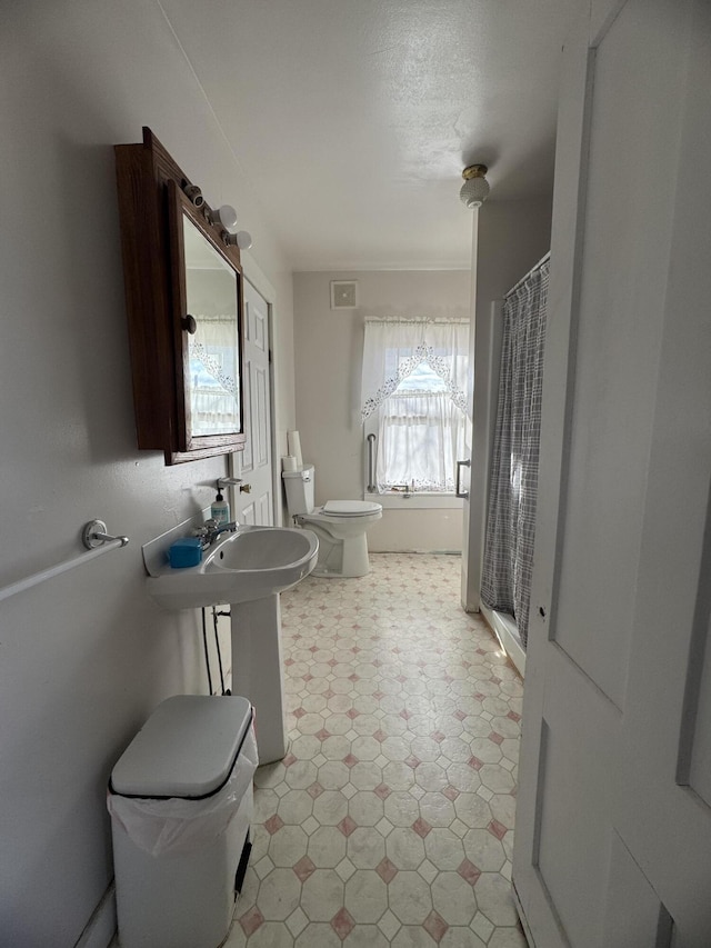 bathroom featuring a shower with curtain, a textured ceiling, and toilet