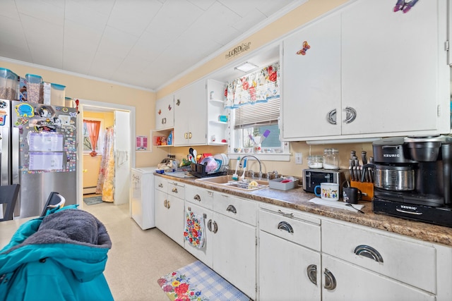 kitchen featuring stainless steel fridge, ornamental molding, washer and clothes dryer, sink, and white cabinets