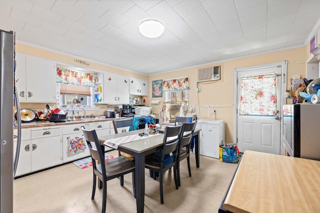 dining area with an AC wall unit, crown molding, and sink