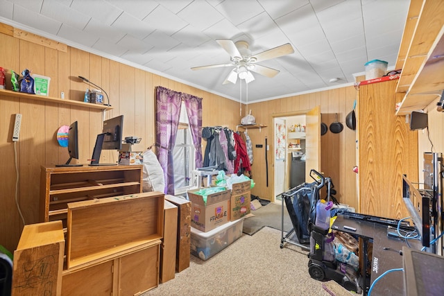 interior space featuring ceiling fan, carpet floors, wood walls, and ornamental molding