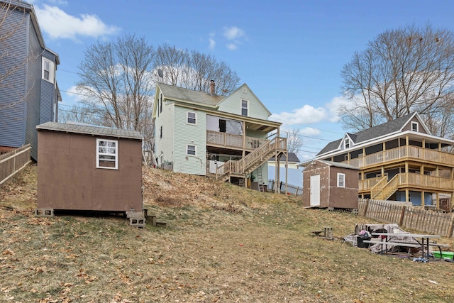 back of property with a yard and a storage unit