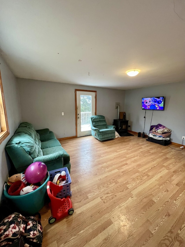 living room with a wood stove and light hardwood / wood-style flooring