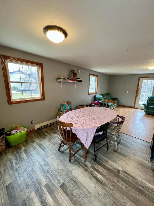 dining room featuring wood-type flooring and a baseboard heating unit