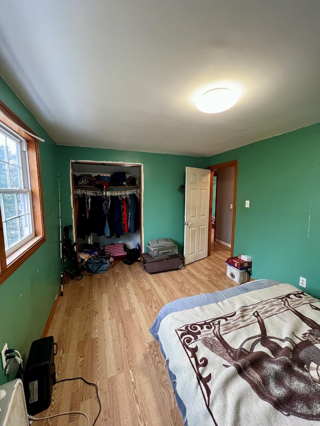 bedroom with a closet, lofted ceiling, and hardwood / wood-style flooring