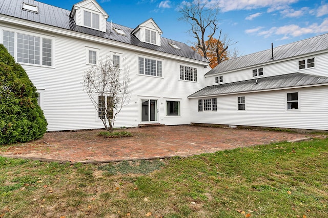 rear view of house featuring a patio and a lawn