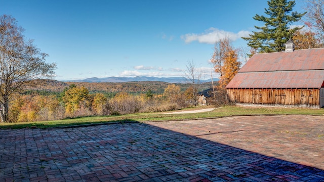 view of patio / terrace with a mountain view and an outdoor structure