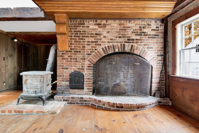 details featuring a wood stove, wood walls, wooden ceiling, and wood-type flooring