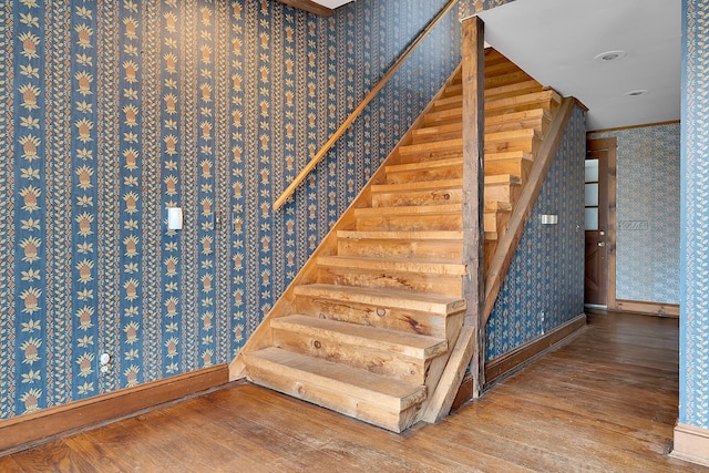 staircase with crown molding and hardwood / wood-style flooring