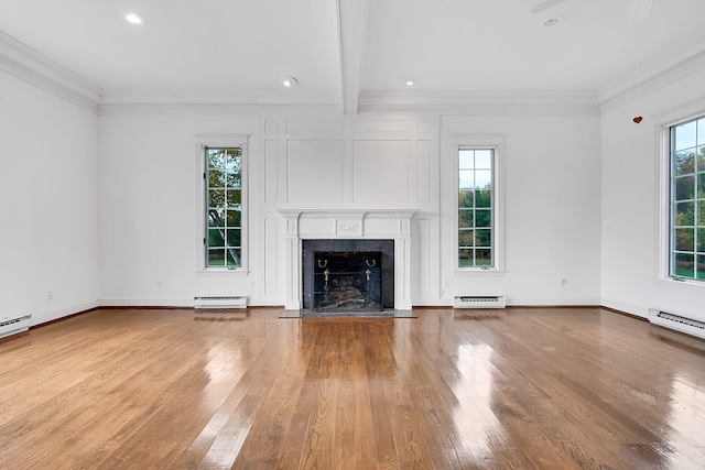 unfurnished living room with baseboard heating, a healthy amount of sunlight, and beam ceiling