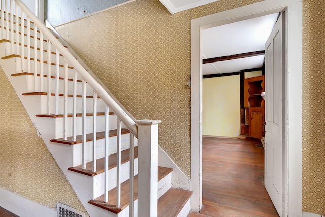 staircase featuring hardwood / wood-style floors and ornamental molding