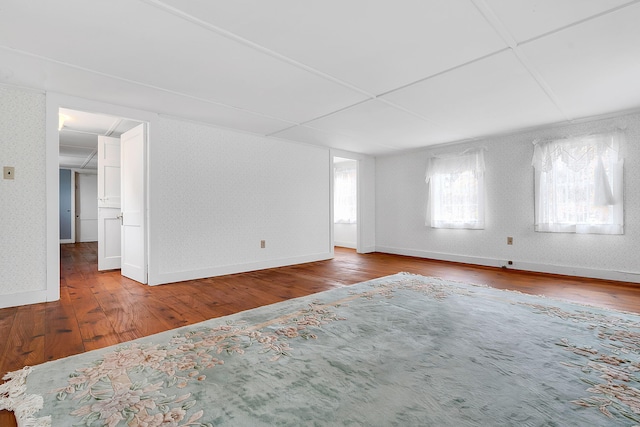 unfurnished room with hardwood / wood-style flooring and a drop ceiling