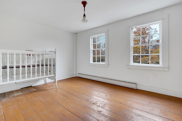 unfurnished bedroom featuring a baseboard radiator and wood-type flooring