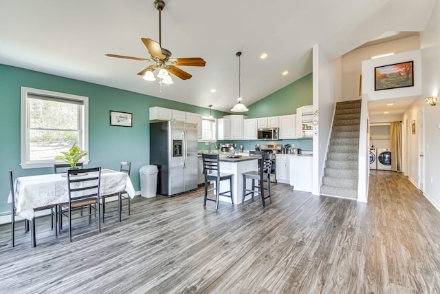433 Works Rd, Jackson, ME 04921 - kitchen with a breakfast bar, white cabinets, separate washer and dryer, appliances with stainless steel finishes, and a kitchen island