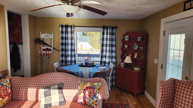 bedroom featuring a ceiling fan, a textured ceiling, baseboards, and wood finished floors