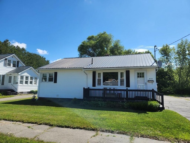 view of front of home featuring metal roof and a front lawn