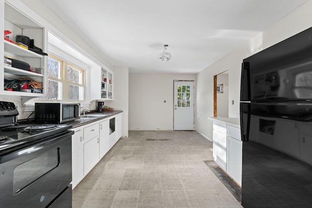 kitchen with sink, black appliances, and white cabinetry