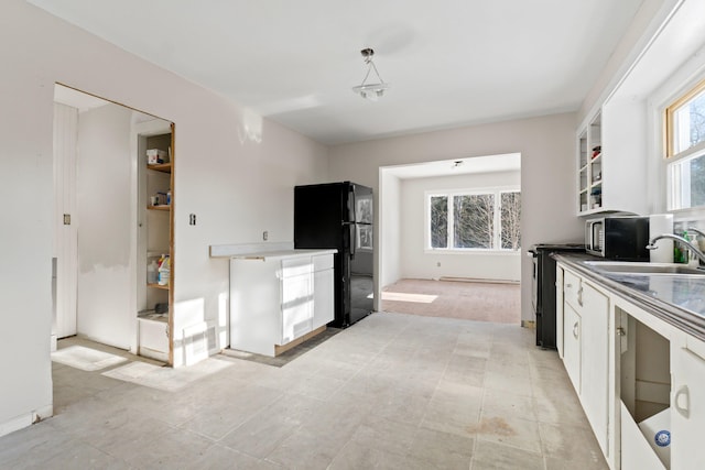 kitchen featuring black refrigerator, electric stove, white cabinets, decorative light fixtures, and sink