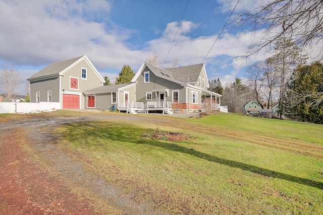 view of front of home with a front yard, a porch, and a garage