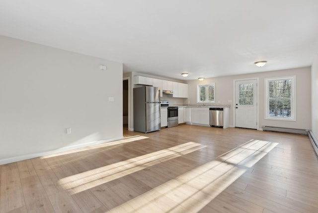 unfurnished living room with light hardwood / wood-style floors and sink