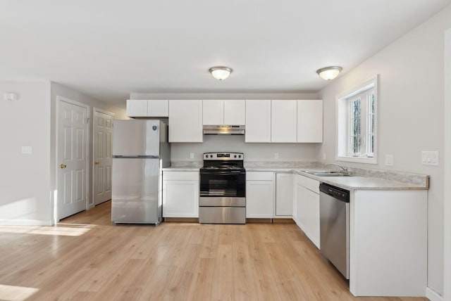 kitchen with sink, white cabinets, light hardwood / wood-style floors, and appliances with stainless steel finishes