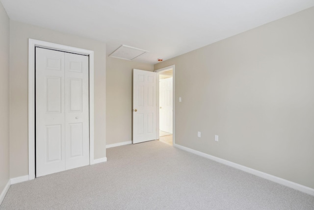 unfurnished bedroom with a closet and light colored carpet