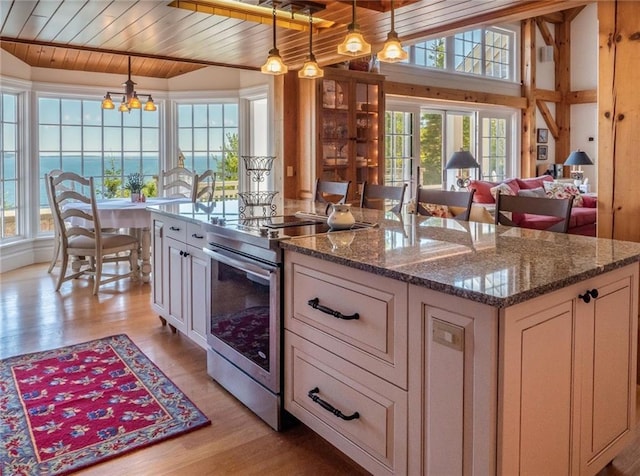 kitchen featuring a water view, electric stove, decorative light fixtures, light hardwood / wood-style floors, and wood ceiling