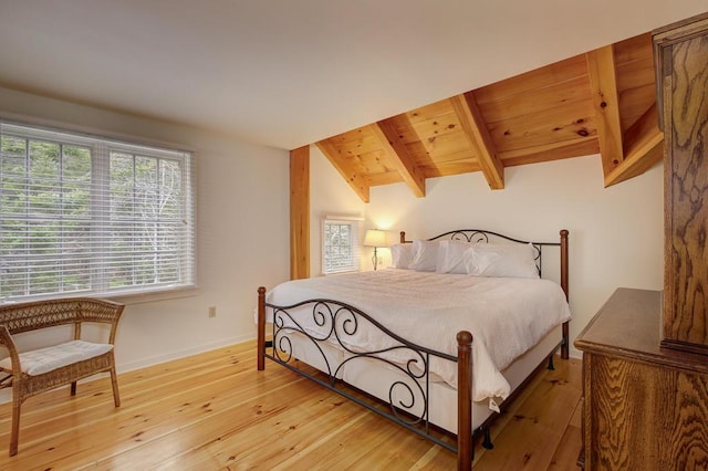 bedroom featuring vaulted ceiling with beams, light hardwood / wood-style flooring, and wood ceiling