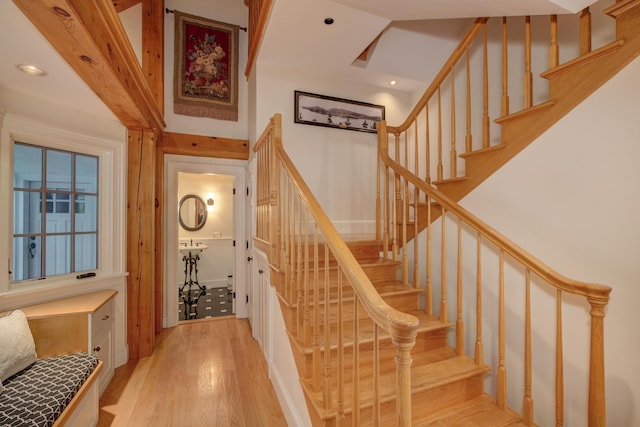 stairs with hardwood / wood-style floors and a towering ceiling