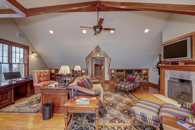 living room with ceiling fan, a fireplace, light hardwood / wood-style floors, and vaulted ceiling