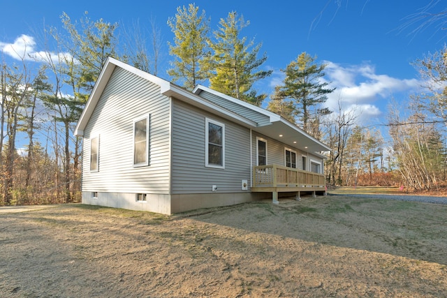 view of side of home with a yard and a wooden deck