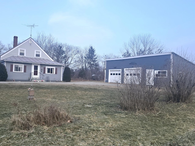 view of front facade with a garage, a front lawn, and an outdoor structure