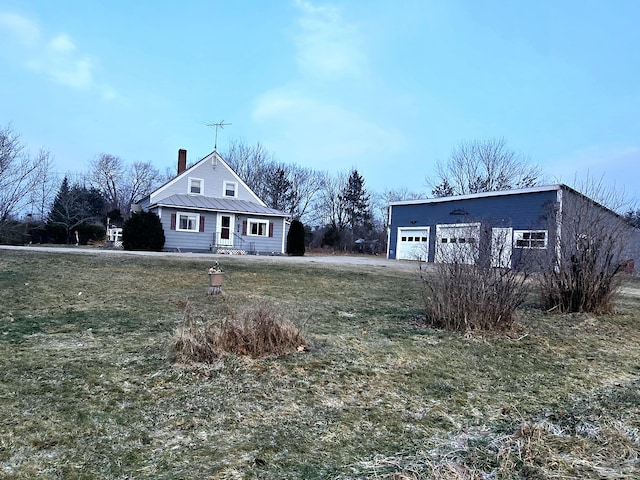 view of front of house with a garage, an outbuilding, and a front yard