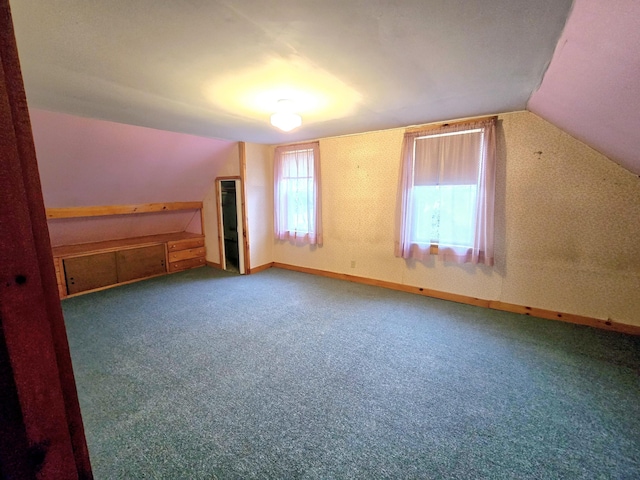 bonus room with carpet flooring and vaulted ceiling