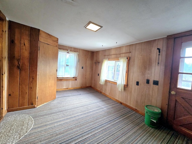 spare room featuring wood walls and light colored carpet